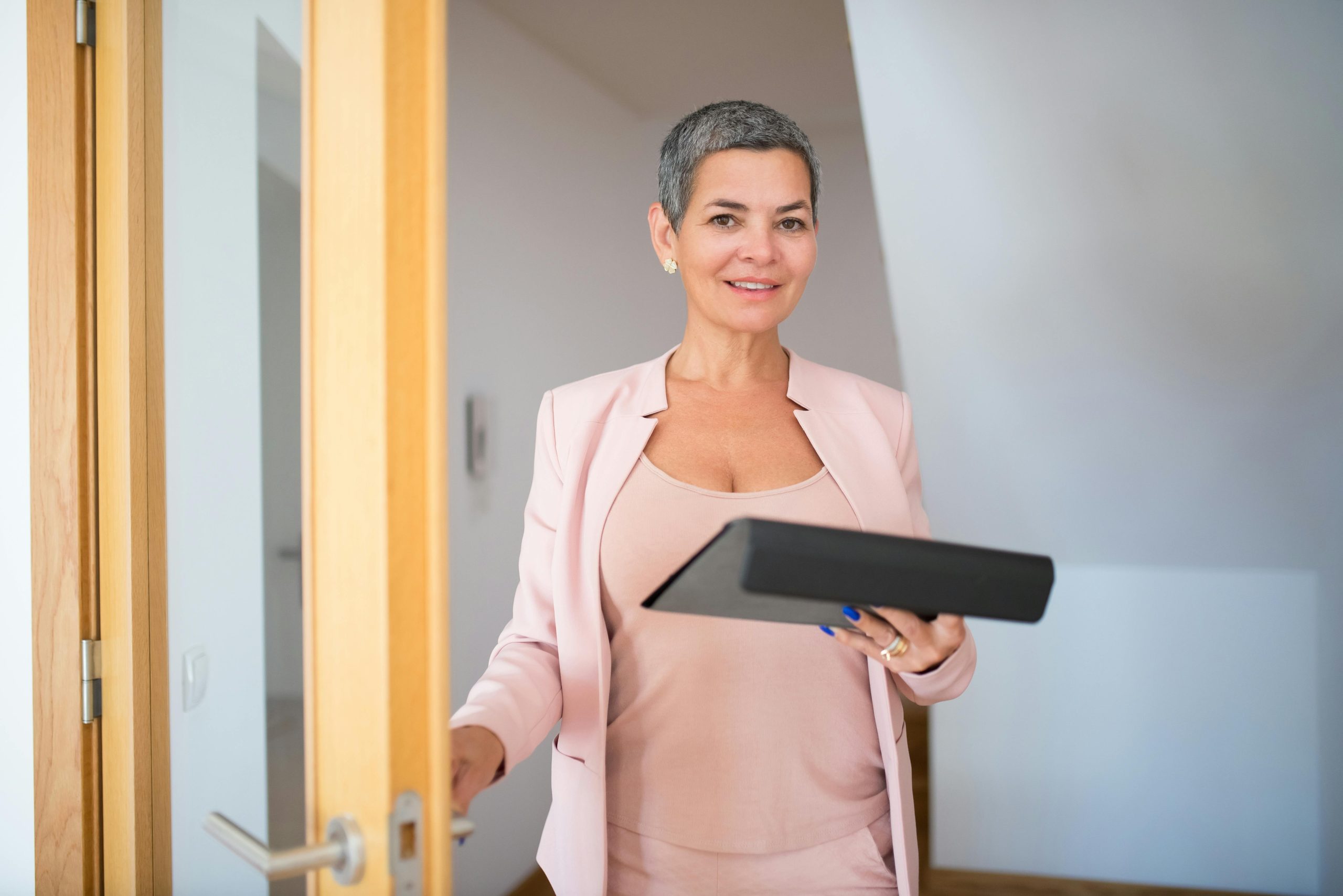 Confident businesswoman with tablet in an office, smiling and approachable.