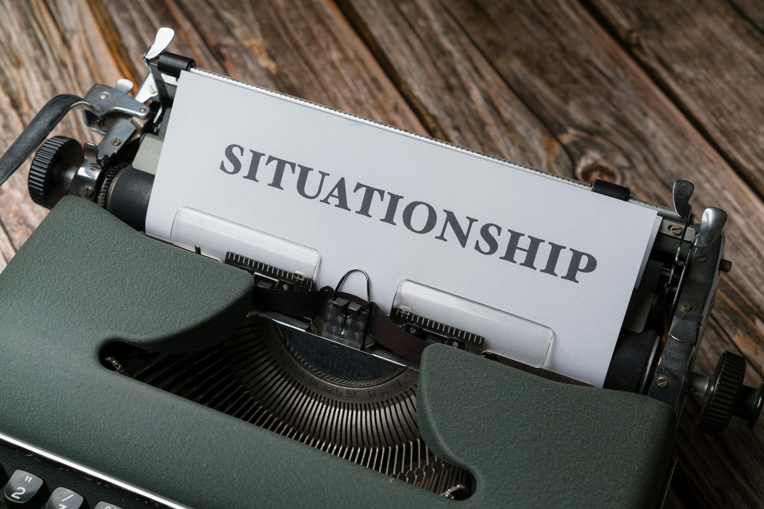 Close-up of a vintage typewriter with "Situationship" typed on paper, symbolizing modern dating concepts.