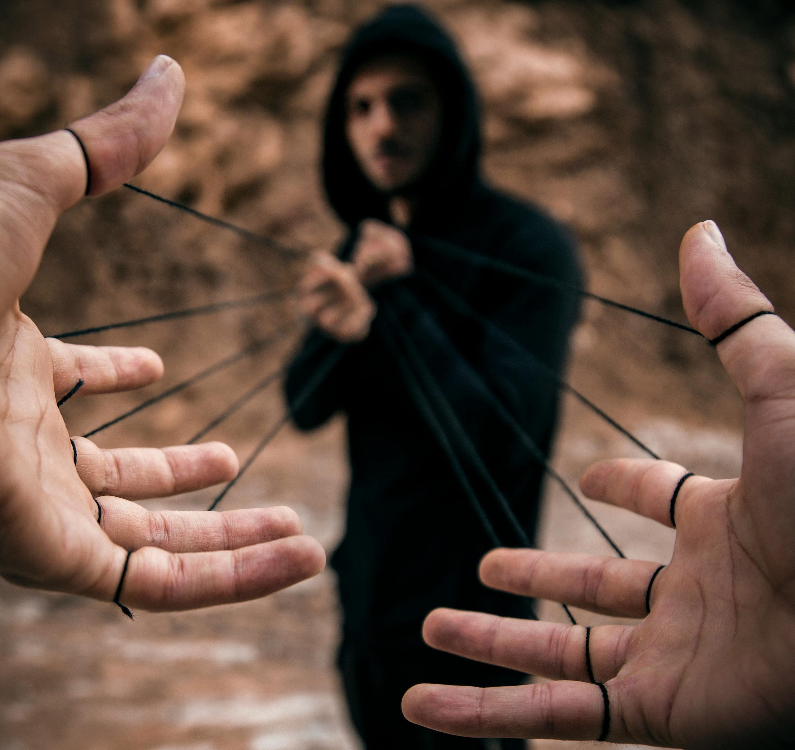 Conceptual image of a man controlling hands with strings, reflecting manipulation.