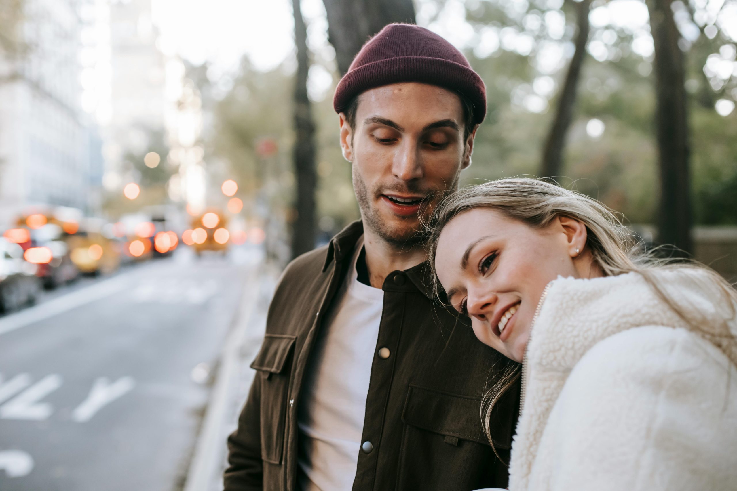 Happy couple enjoying a winter day out in an urban park, sharing smiles and warmth.