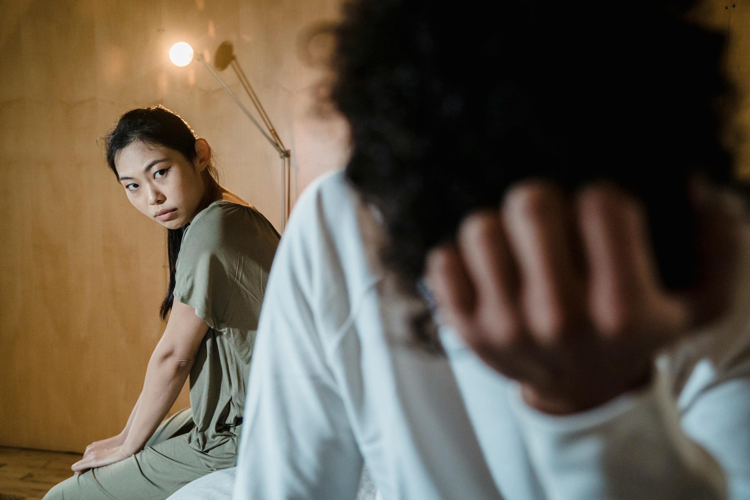 A couple experiencing tension and emotional crisis in a dimly lit room.
