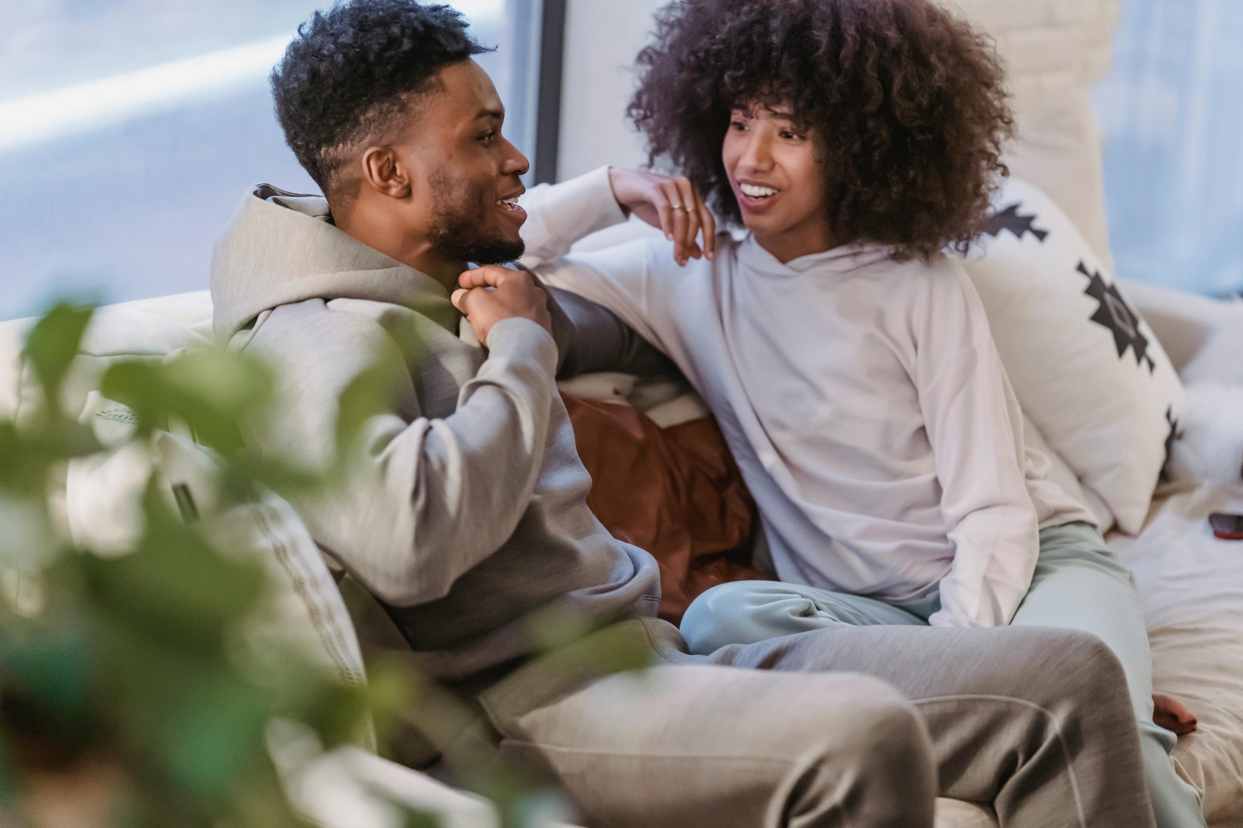 A happy couple enjoying a relaxed weekend indoors, sharing joyful conversation and comfort.
